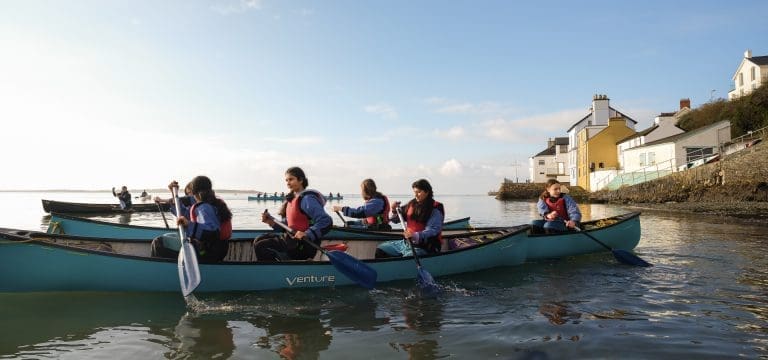4 teams of school pupils in three person canoes on a lake in Snowdonia Wales