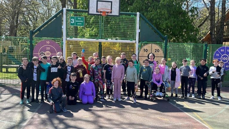 school group having a photo taken on an astro football pitch