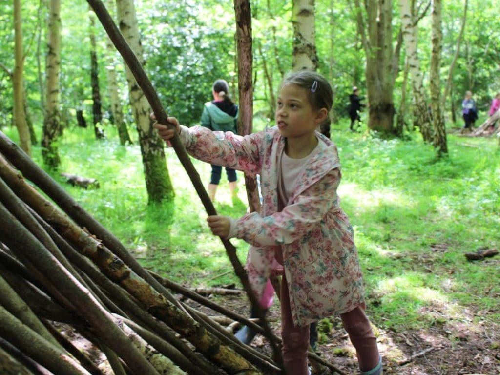 pupil making den out of wood