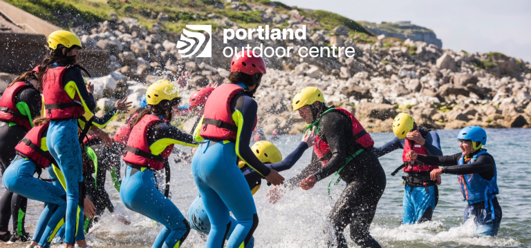 school group playing on a beach at the seaside