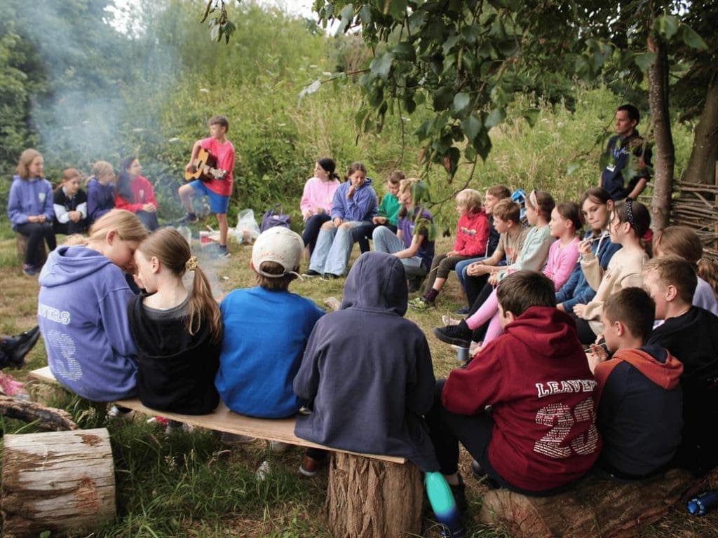 school group around a camp fire