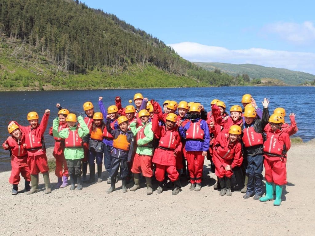 school group with hard hats and water proof stuff on