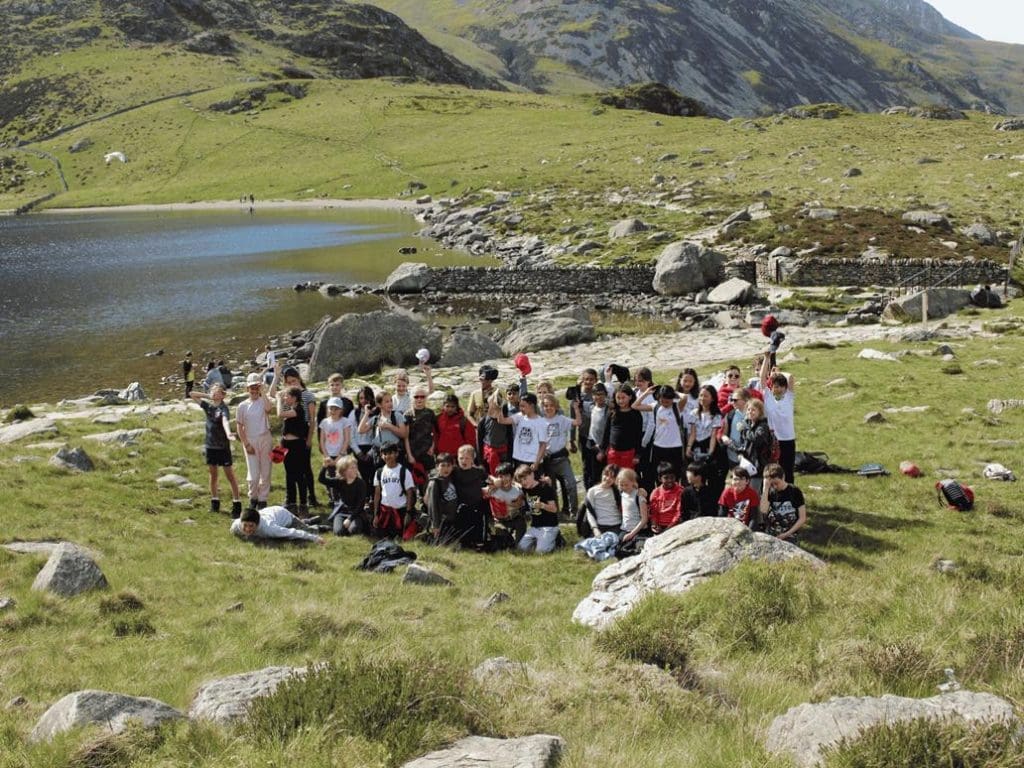 school group on a school trip having a great time near a lake in the Welsh mountains