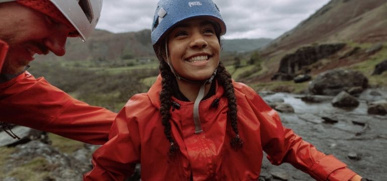 school pupil with instructor being helped out the water