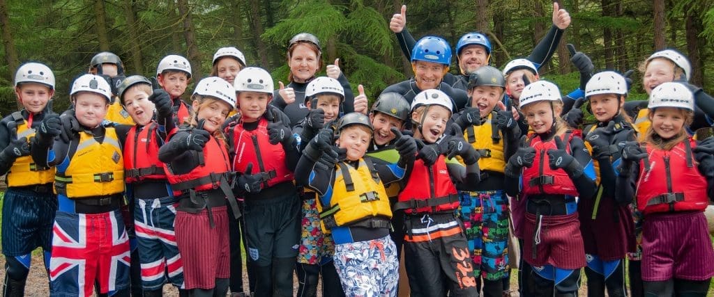 image of school group in water clothing and hard hats smiling and giving the thumbs up