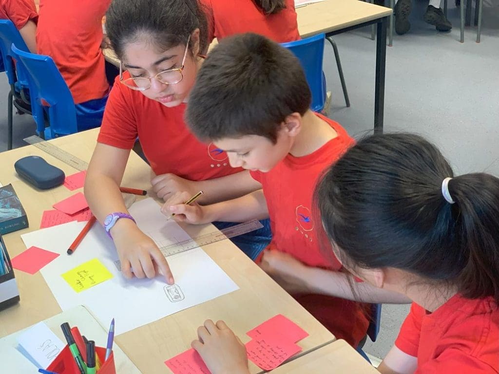 school pupils in a classroom solving puzzles and group taks at an outreach workshop