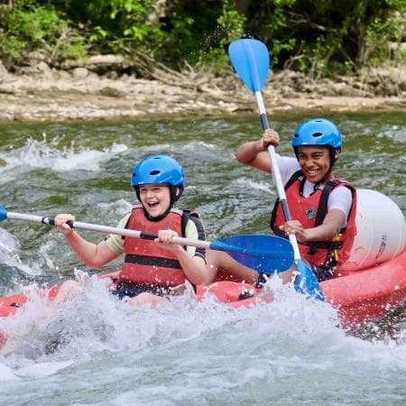 two students on white water rapid river in a kayak