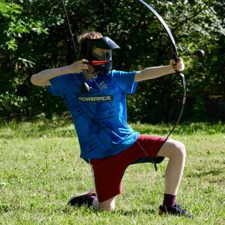 school pupil in an archery field with a bow and arrow
