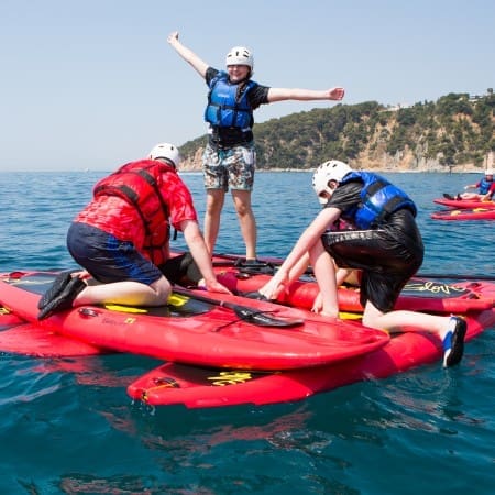 three school pupils on flat kayaks in the sea