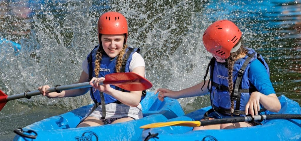 two students in canoes on a lake