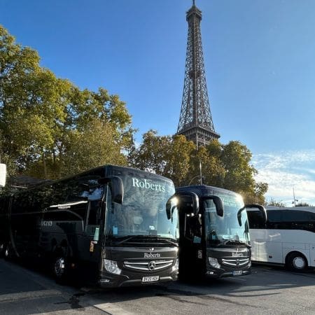 two coaches parked near the Eiffel tower in Paris France