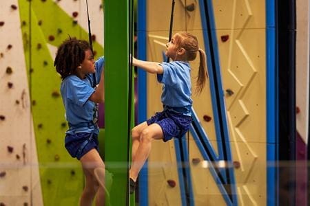 two primary school children on an indoor climbing wall