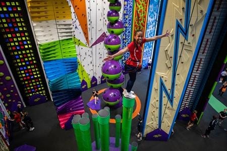 girl on indoor activity climbing poles