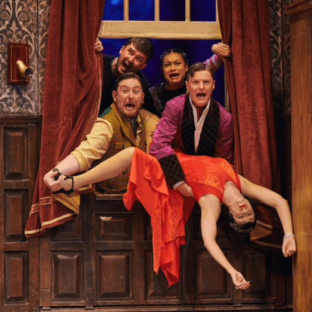 actors on stage waving through a window