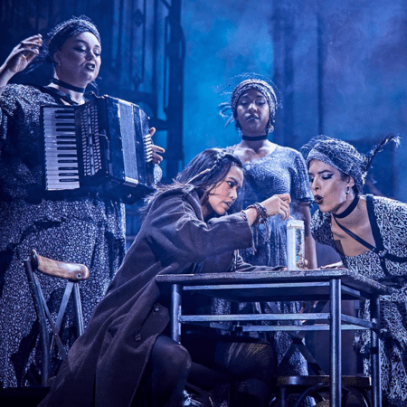 actors at a table and chairs on stage at Lyric Theatre London