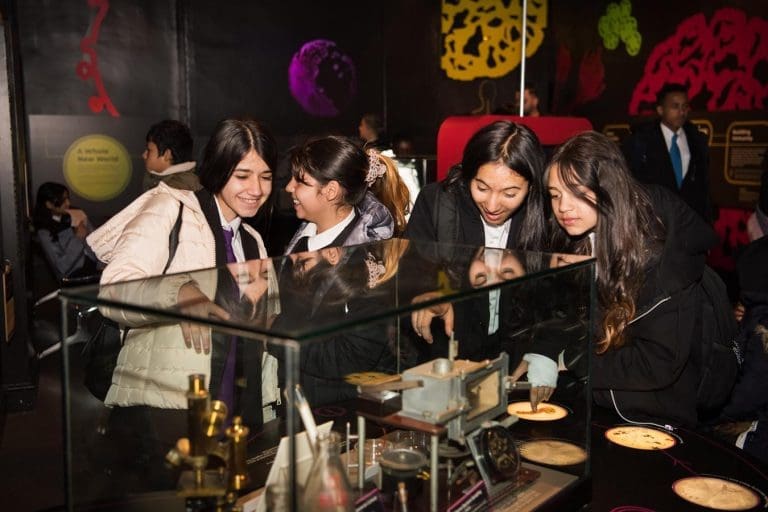 school pupils looking at old medical instruments in a glass exhibition table