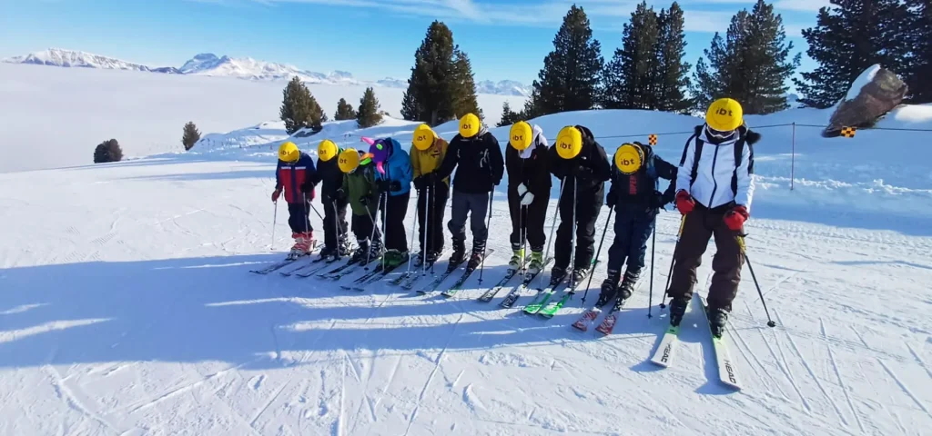 group of school students in ski gear on a ski slope