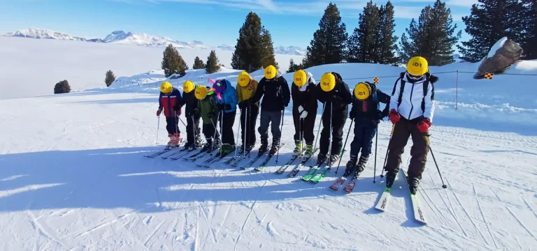 group of school students in ski gear on a ski slope