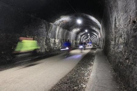 school trip pupils cycling under a bridge