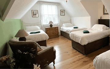 internal accommodation room with 4 beds side tables and chair