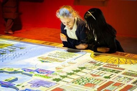school group looking at exhibition Map and history information