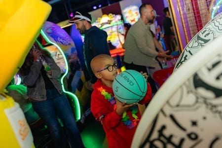 school pupil playing basket ball game in arcade