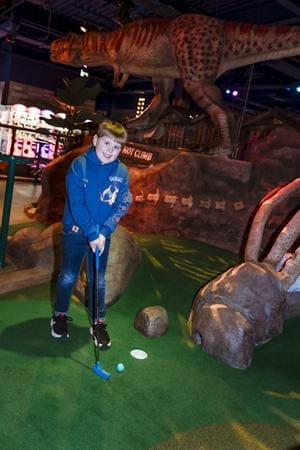 school pupil playing on a crazy golf course