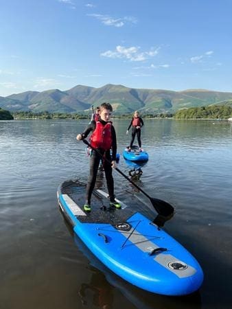 school pupil on a paddle board on a lake