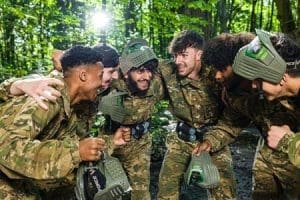 students with combat gear and laser tag guns in forest