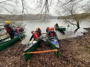 group of students on lake in canoes