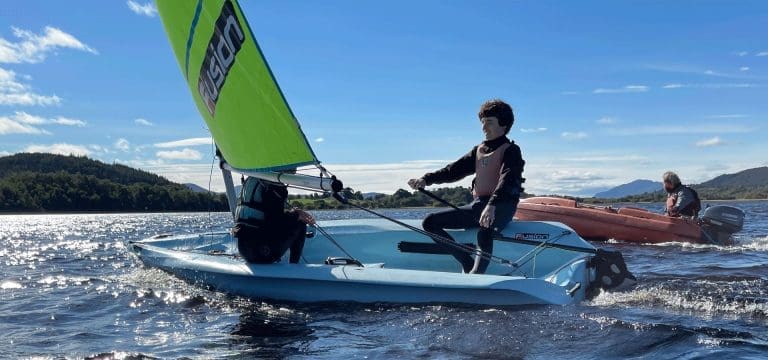 pupils on a small boat sailing on a lake at Cairngorms national park